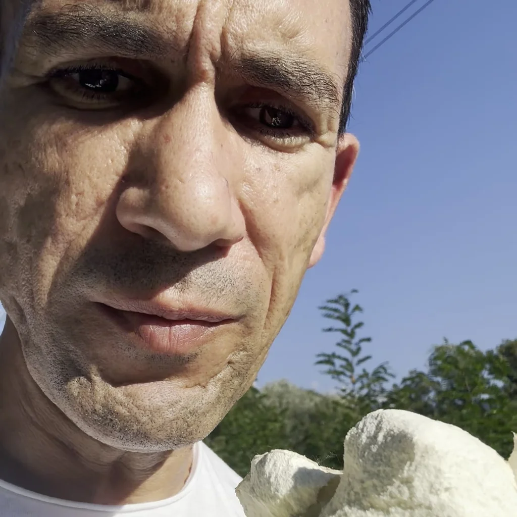 Massimo Gentili nei pascoli d'alta quota con una Calvatia utriformis aperta, mostrando la gleba interna spugnosa